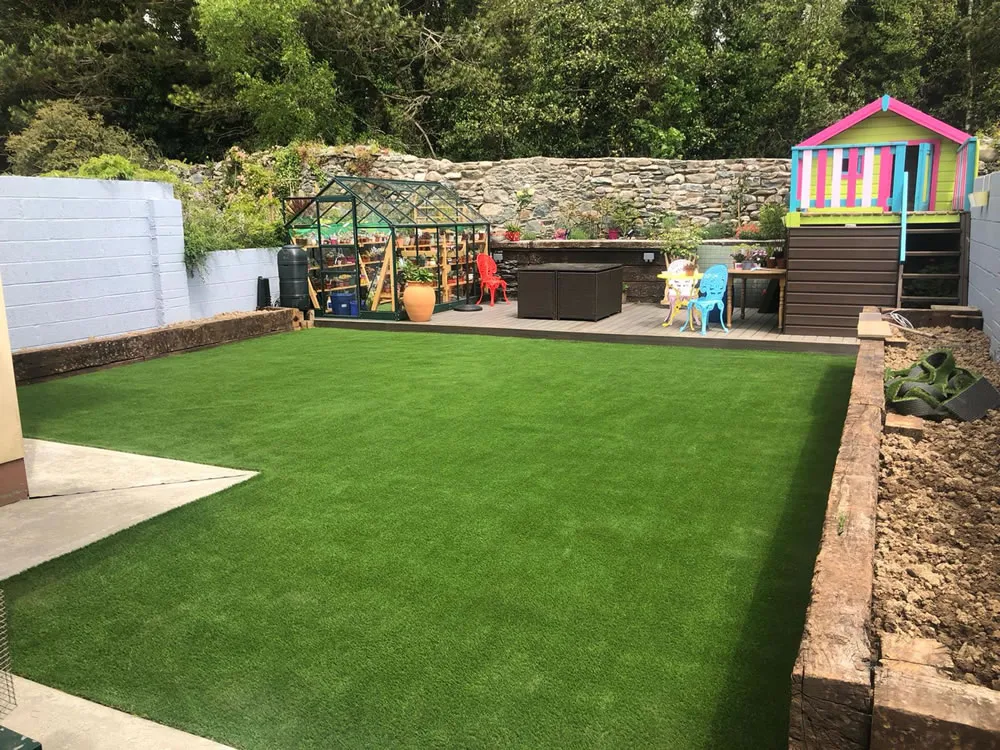 Landscaped rear garden in Kent with fresh artificial lawn, fencing and raised borders